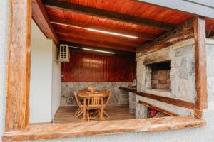 a dining room with a table and a stone fireplace at Korana River Retreat with Sauna & Jacuzzi and View by Destination GREEN Croatia in Barilović