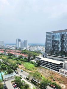 eine Skyline der Stadt mit einem hohen Gebäude und einer Straße in der Unterkunft Lang Retreat Apartment - Resort Pool & Elite Gym in Ho-Chi-Minh-Stadt