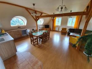 a kitchen and living room with a table and chairs at Penzion Vila Křenov in Bernartice
