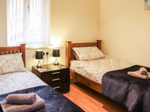 a bedroom with two beds and a table with two lamps at Berwyn - Uk48507 in Bala +3 photos