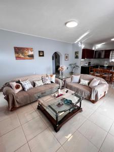a living room with two couches and a coffee table at Maria 's aparment in Mursi