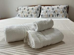 Una pila de toallas encima de una cama en HBS Rent Rooms Canonico, en Sestu