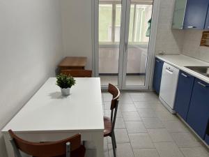 una cocina con una mesa blanca con sillas y una planta en HBS Rent Rooms Canonico, en Sestu 6 fotos más