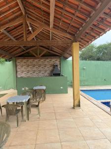 a patio with tables and chairs next to a pool at Aconchegante Casa em Gravatá - Casa 05 in Gravatá