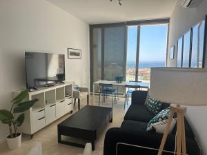 a living room with a couch and a flat screen tv at Carboneras - Holidays Time in Carboneras