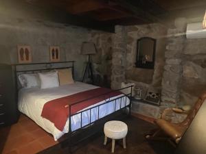 a bedroom with a bed in a stone room at Casa da Costinha in Cinfães +40 photos