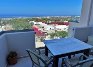 a blue table and chairs on a balcony with a view at Lovely Hot-L in Fira