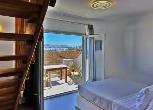 a bedroom with a bed and a balcony with a table at Lovely Hot-L in Fira +195 photos