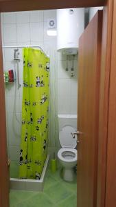 a bathroom with a toilet and a shower curtain with cows at Gloria Apartments in Herceg-Novi +15 photos