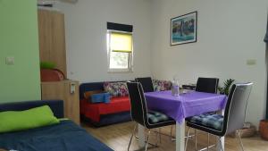 a living room with a purple table and chairs at Gloria Apartments in Herceg-Novi