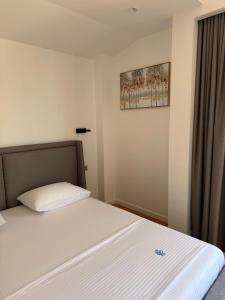 a bedroom with a white bed with a window at Vironas Hotel in Himare