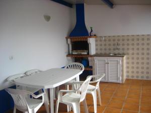 eine Küche mit einem weißen Tisch und weißen Stühlen in der Unterkunft big apartment in the beach in Zambujeira do Mar + 13 Fotos