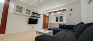 a living room with a blue couch and a tv at CASA ELEO in Arrecife