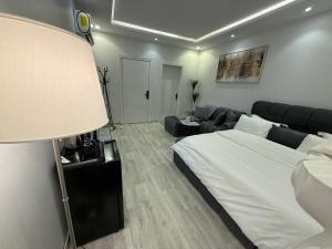 a bedroom with a large bed and a couch at شقة تأجير يومي استوديو جديد بأثاث هادئ وأنيق in Riyadh