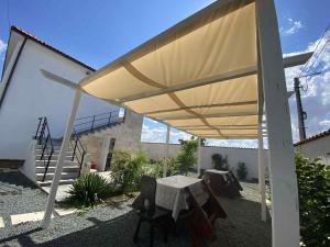 a patio with a table and a yellow umbrella at Pe Colț in Vama Veche +4 photos