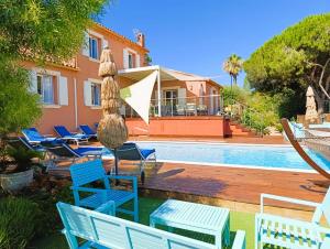 a villa with a swimming pool and blue chairs at Superbe Villa 5 étoiles Presqu'Île de Giens la Madrague Rita la Villa d'Or vue mer piscine in Hyères