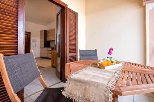 サン・テオドーロにあるMaison Apartments San Teodoro Centerの木製のテーブルと椅子のあるキッチンとダイニングルーム