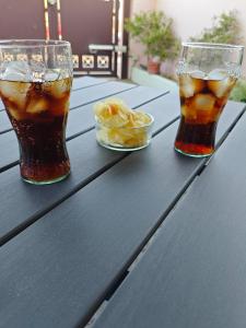 a table with two glasses of soda and a bowl of fruit at la Casa di Giò in Pulsano