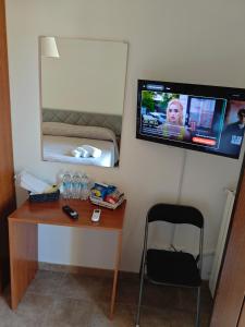 a room with a desk and a tv on the wall at la Casa di Giò in Pulsano