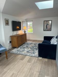 a living room with a couch and a flat screen tv at The Silverdale Court No6 in Farnborough