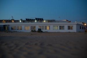 a white house on the beach at night at Apartamentos Calypso in Punta Umbría