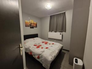 a small bedroom with a bed with flowers on it at Maison Bonne Humeur Achouffe in Houffalize