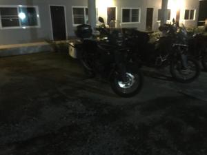 un grupo de motocicletas estacionadas en un estacionamiento por la noche en boomhousehotel, en Chiang Khong