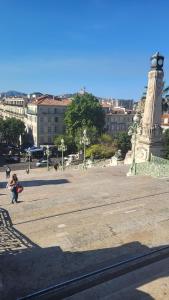 a person walking in a plaza with a clock tower at Anora in Marseille