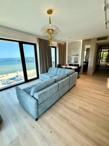 un soggiorno con divano e vista sulla spiaggia di Luksusowy apartament Infinity Chill Baltic Spa a Międzyzdroje