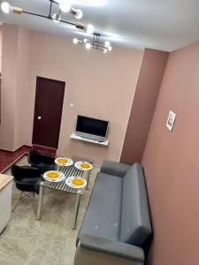 een woonkamer met een bank en een tafel met borden erop bij Апартамент за гости Николови in Vidin