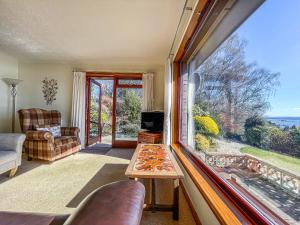 a living room with a table and a large window at Chanonry View Holiday Cottage in Fortrose