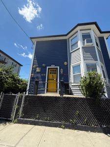 a blue house with a yellow door at Luxurious Bedroom with Private Entrance & En-suite Bathroom in Fall River