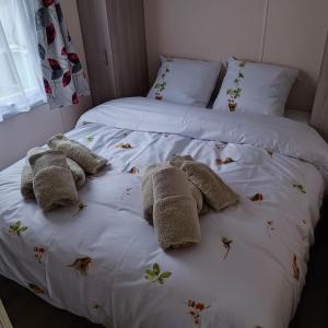 two beds with towels and butterflies on the sheets at Caravan Aan Zee Arnani in Middelkerke