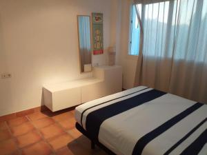 a small bedroom with a bed and a mirror at Adosado tres habitaciones, en Bahía de la Plata, Zahara de los atunes in Zahara de los Atunes +19 photos