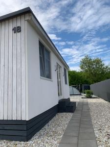 a small white house with a gravel driveway at Balatonszabadi Privát Apartman in Balatonszabadi