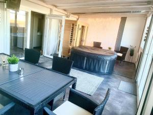 a patio with a table and chairs and a tub at Balatonszabadi Privát Apartman in Balatonszabadi