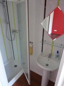 a white bathroom with a shower and a sink at Joli cocon au cœur de la nature in Baracé