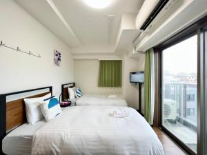 una camera d'albergo con due letti e una grande finestra di Otsuka No3 Mansion #JR Yamanote Line#Fixed Wifi a Tokyo