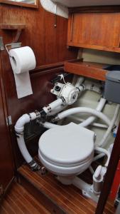 a bathroom with a toilet and some pipes at Accommodation on a sailboat in Sysmä harbour in Sysmä