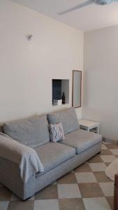 a couch in a living room with a white wall at Makao in Kilifi
