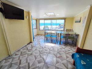 a dining room with a table and chairs and a television at Cabañas Vuelo de Gaviotas in Curanipe