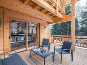 a porch of a cabin with chairs and a table at Chalet neuf 10 pers, charme et confort à Serre Chevalier - FR-1-808-20 in Le Monêtier-les-Bains