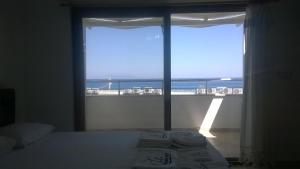 a bedroom with a bed and a view of the ocean at Palmaris Apart Palamutbuku in Palamutbuku