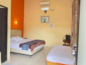 a bedroom with two beds and a tv in it at HOMESTAY RJS Pulau Tidung NWR in Pulau Tidung-besar