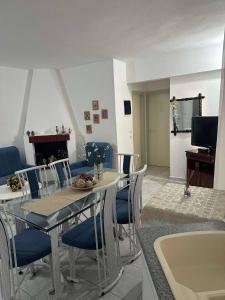 una sala da pranzo con tavolo, sedie e camino di Nikoletas Apartment Pefkochori a Pefkohori