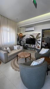 a living room with a couch and a piano at Sadeem Village & Chalet in Al Shafa +170 photos