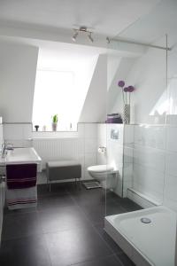 a white bathroom with a sink and a toilet at Ferienhaus Marina in Baden-Baden
