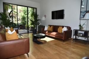 a living room with two couches and a flat screen tv at Villa Le Loft by Festif Azur 4-Star 200m2 House with Garden, 5-Min Walk to Palais des Festivals and Beaches in Cannes