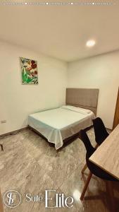 Un dormitorio con una cama, una mesa y una silla. en Suite Relax Valledupar, en Valledupar