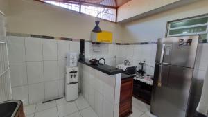 a small kitchen with a stainless steel refrigerator at Apartamento funcional próximo ao Shopping Paraíso e comércios in Santarém